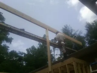 Carpenter setting a ridge beam over a new addition frame — Ice Dam Removal by Roofing Brothers in Scottsmoor