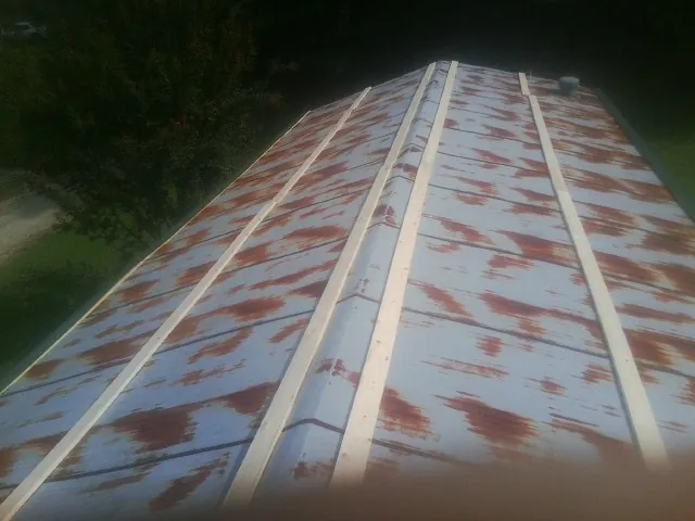 Rusted metal roof panels with new wood purlins before replacement — Storm Damage Roof Repair in Scottsmoor by Roofing Brothers