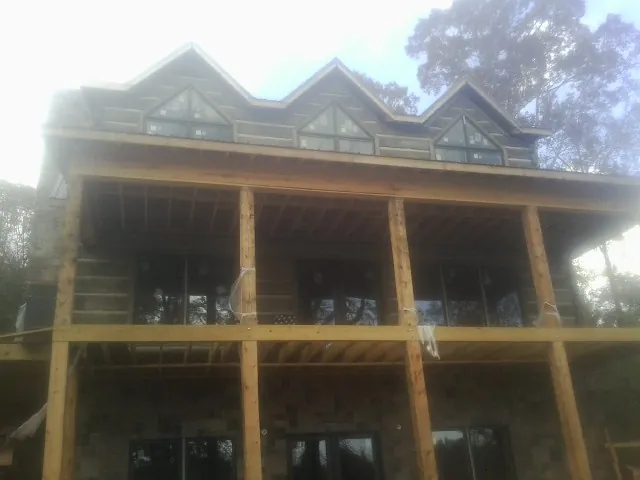 Dormers and porch framing on a large log home under construction — Roof Coating work by our crew in Scottsmoor