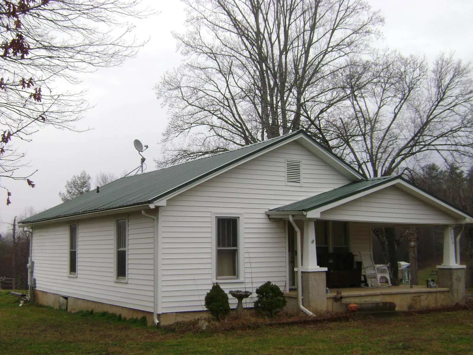 Green metal roof on a white bungalow with a side porch in Scottsmoor