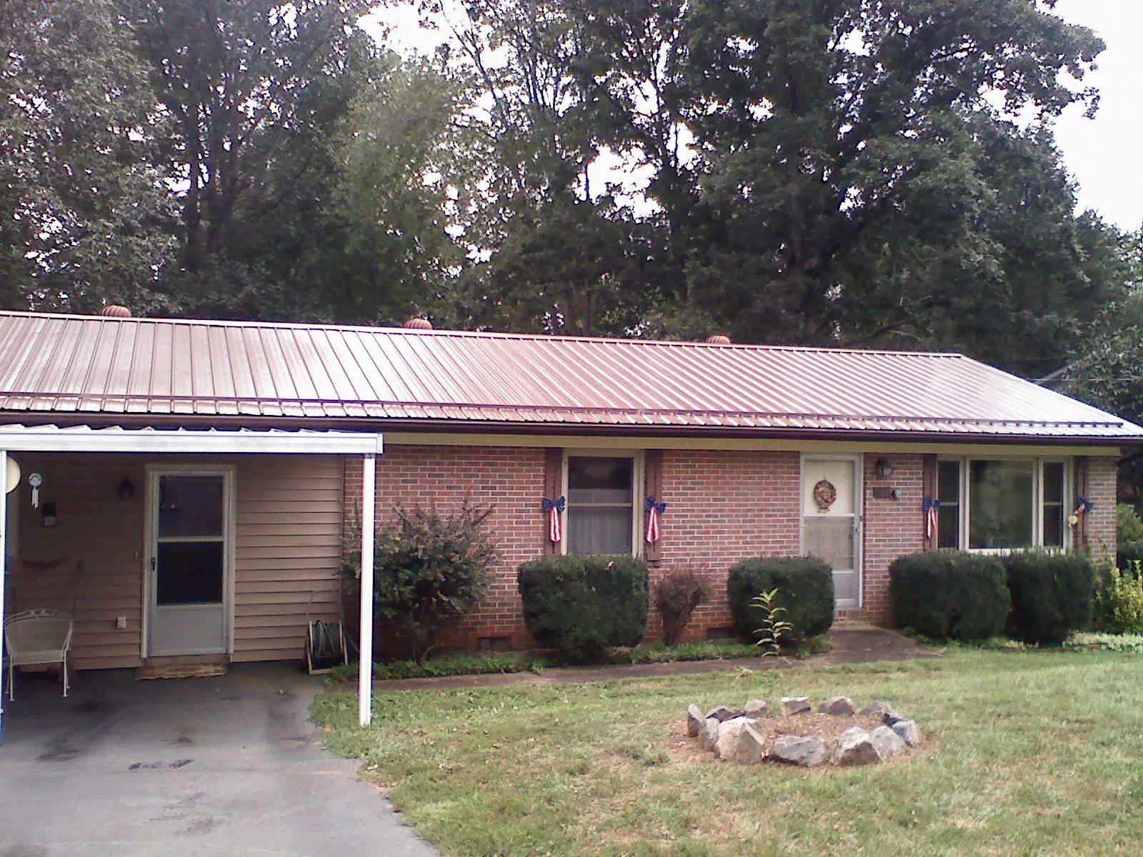 Bronze metal roof and carport on a brick ranch home — Roof Repair work by our crew in Scottsmoor